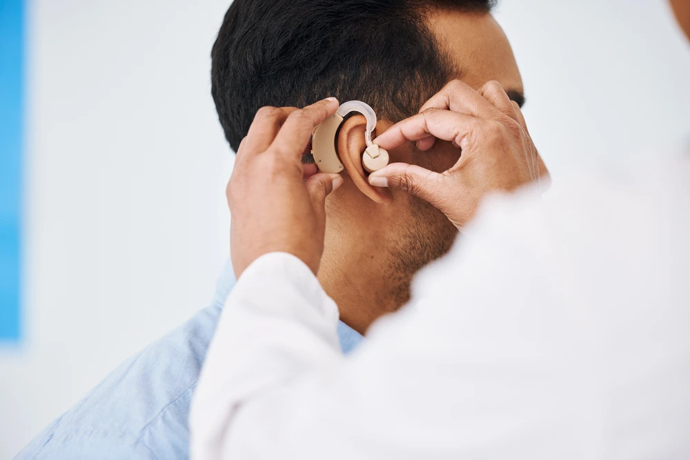 Docteur, homme et aide auditive à l'oreille pour le soutien médical, le bien-être et l'innovation du handicap