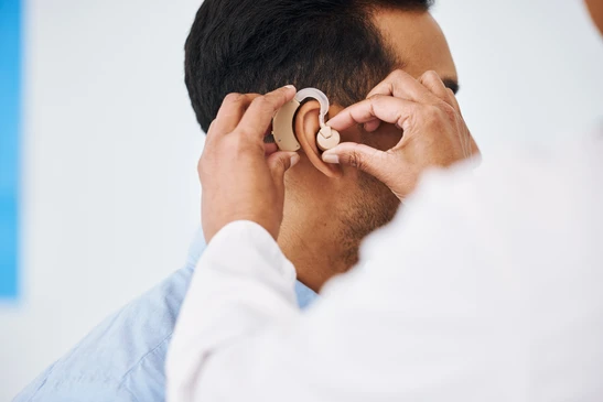 Docteur, homme et aide auditive à l'oreille pour le soutien médical, le bien-être et l'innovation du handicap