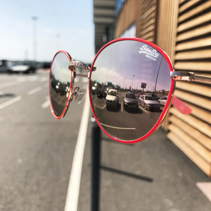 Intérieur d'un magasin d'optique avec présentation de lunettes de vue sur présentoirs en bois clair